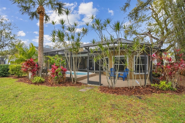 rear view of house with a yard, a patio, a lanai, and an outdoor pool