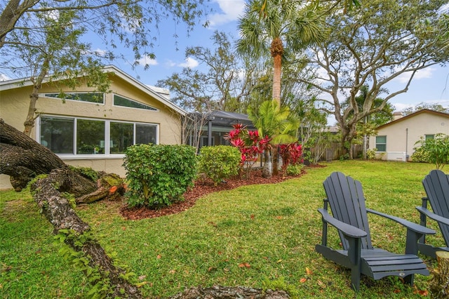 view of yard featuring glass enclosure and fence