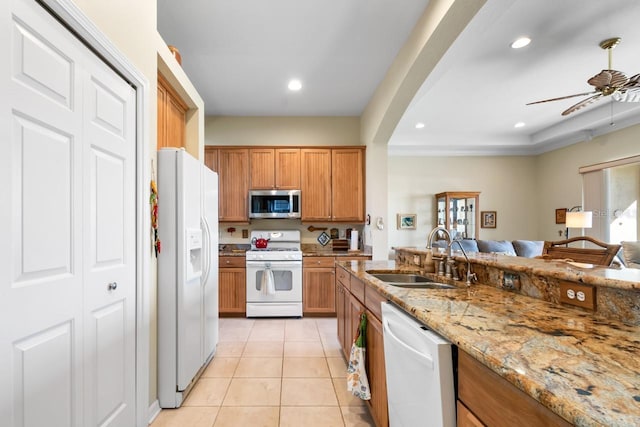 kitchen with sink, light stone counters, light tile patterned floors, ceiling fan, and white appliances