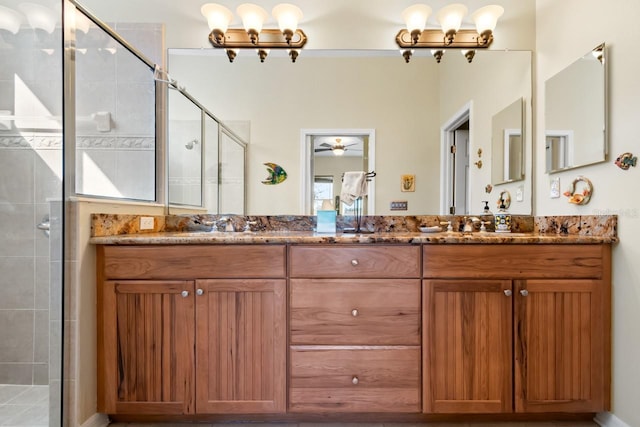 bathroom with ceiling fan with notable chandelier, vanity, and a shower with door