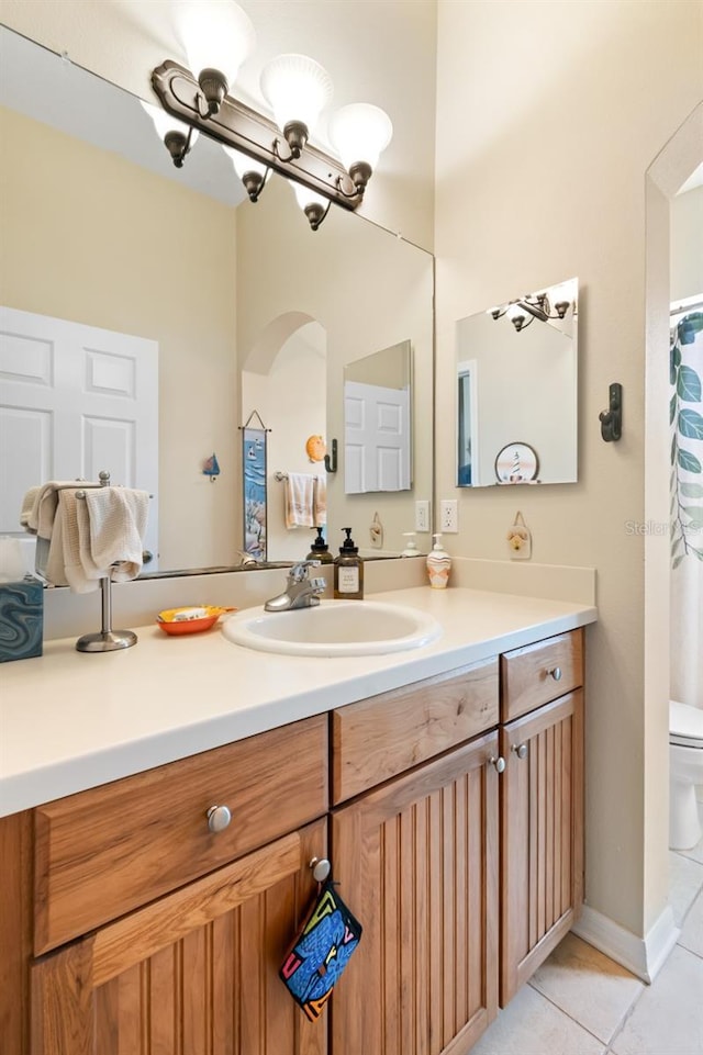 bathroom with vanity, toilet, and tile patterned flooring