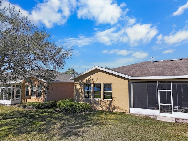 back of property with a yard and a sunroom