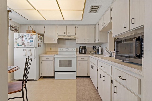 kitchen featuring tasteful backsplash, sink, and white appliances