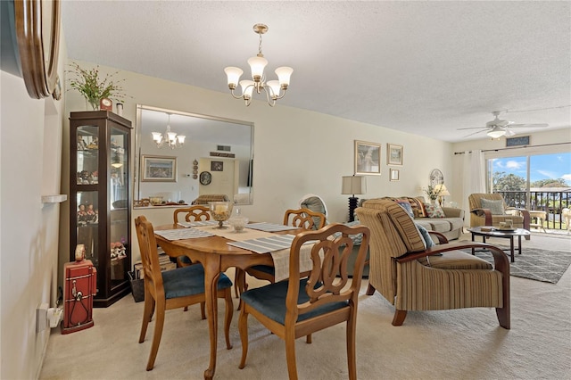 carpeted dining area with ceiling fan with notable chandelier and a textured ceiling