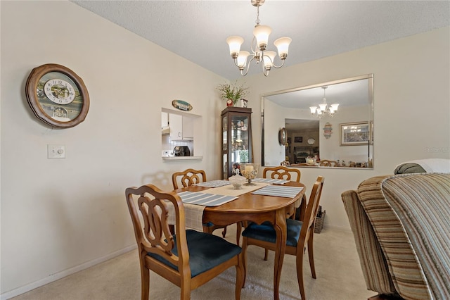 dining room with light carpet and a notable chandelier