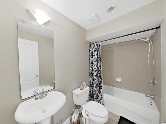 full bathroom featuring sink, shower / bath combo with shower curtain, and toilet