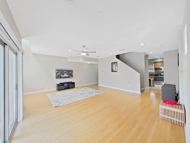 living room with ceiling fan and light wood-type flooring