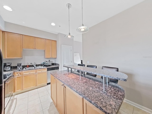 kitchen featuring appliances with stainless steel finishes, light brown cabinetry, a center island, and dark stone counters