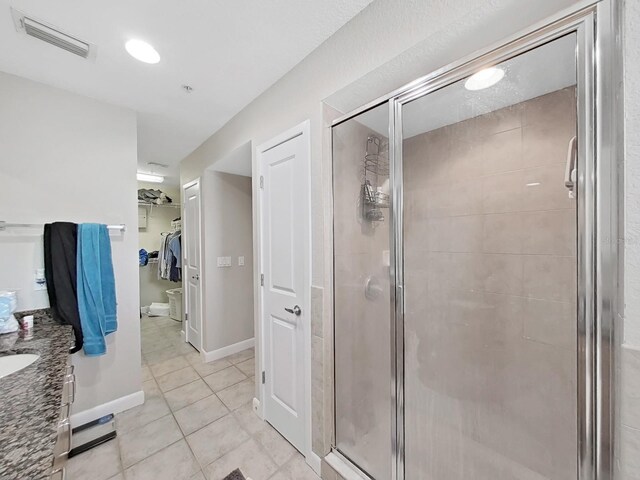 bathroom featuring vanity, tile patterned flooring, and a shower with door