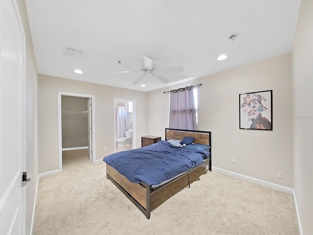 carpeted bedroom with a walk in closet, connected bathroom, ceiling fan, and a closet