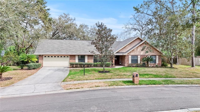 view of front facade with brick siding, concrete driveway, an attached garage, a front yard, and fence