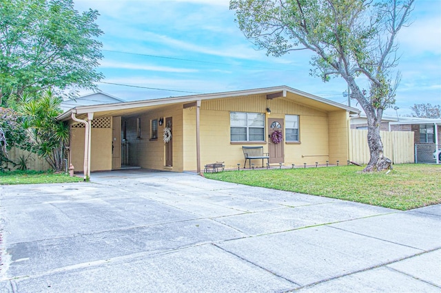 ranch-style home featuring a front lawn and a carport