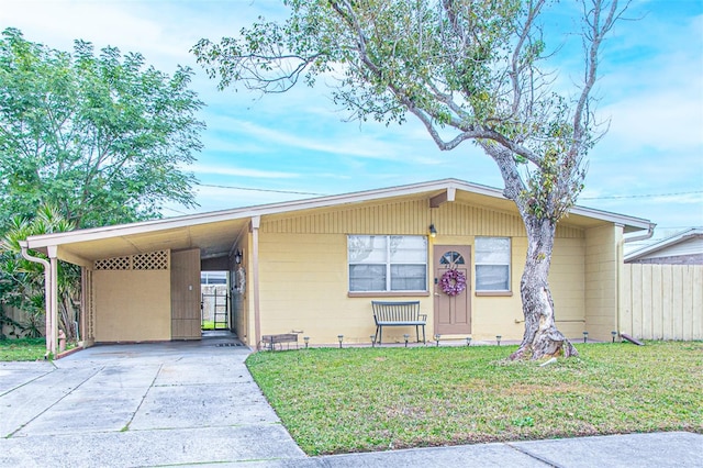 view of front of home with a carport and a front lawn