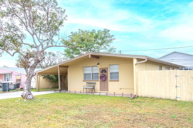 view of front of home with a front yard and a carport