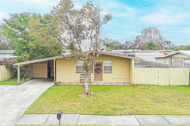 ranch-style house featuring a carport and a front yard