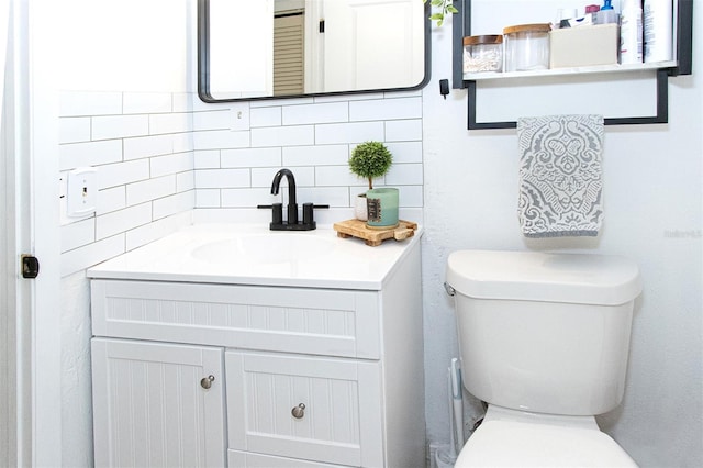 bathroom with tasteful backsplash, vanity, and toilet