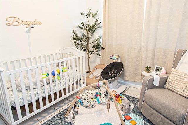 bedroom with tile patterned flooring and a nursery area