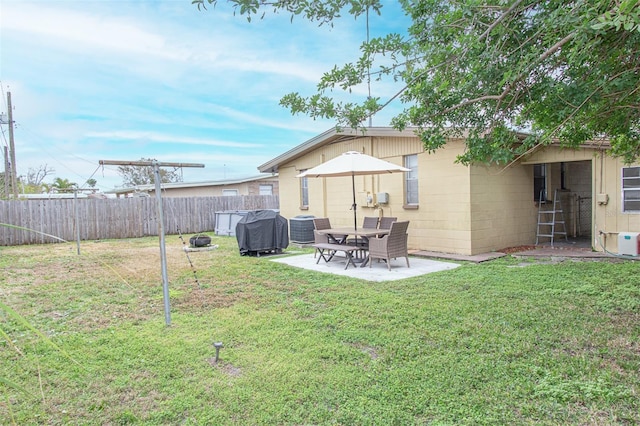 rear view of house with cooling unit, a patio area, and a lawn