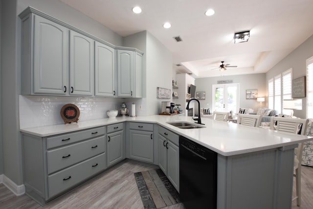 kitchen featuring sink, gray cabinets, kitchen peninsula, and black dishwasher