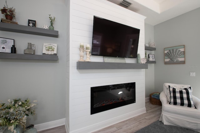 living room with hardwood / wood-style flooring and a large fireplace