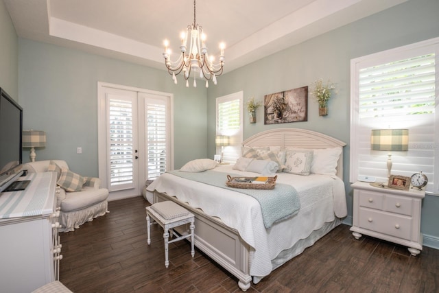 bedroom with multiple windows, dark wood-type flooring, access to outside, and a raised ceiling