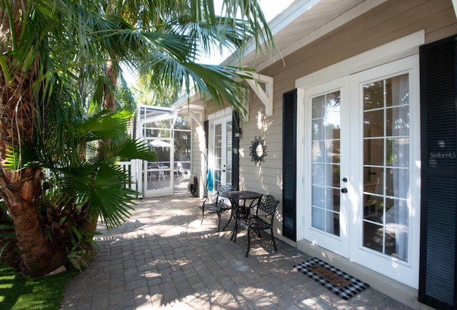 view of patio featuring french doors and glass enclosure