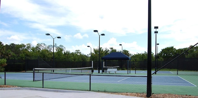 view of tennis court featuring fence