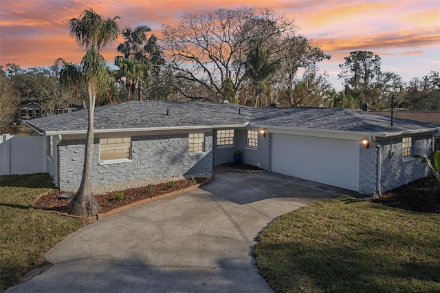 single story home with a garage and a lawn