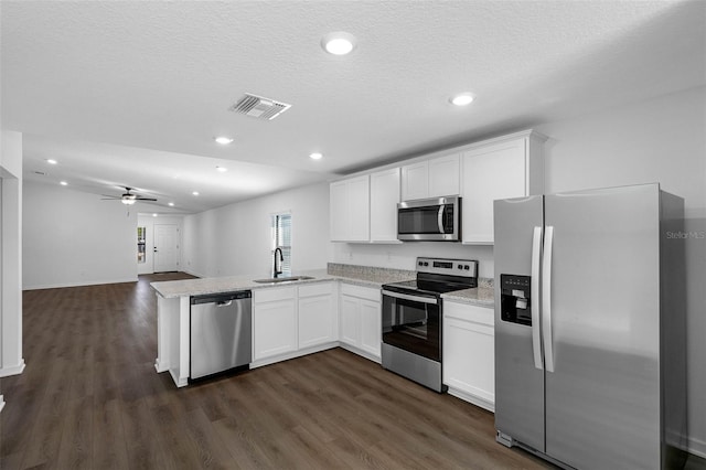 kitchen featuring sink, white cabinetry, appliances with stainless steel finishes, dark hardwood / wood-style flooring, and kitchen peninsula