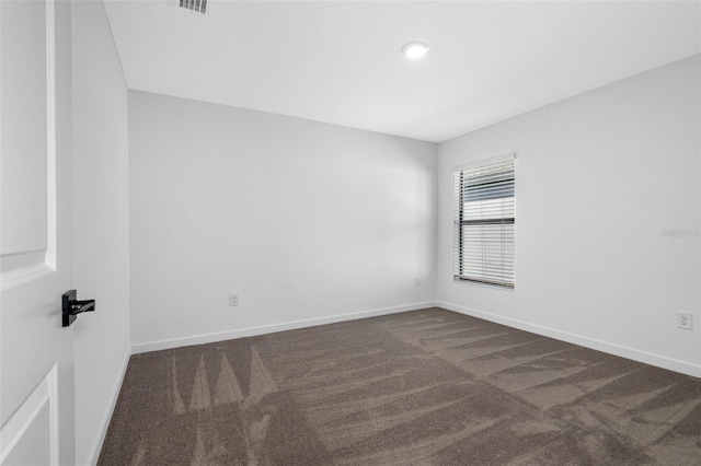 empty room featuring dark colored carpet