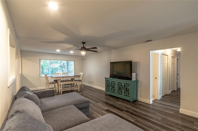 living room with dark wood-type flooring and ceiling fan