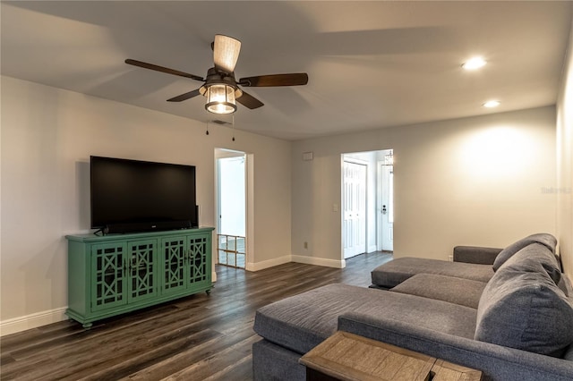 living room with dark hardwood / wood-style flooring and ceiling fan