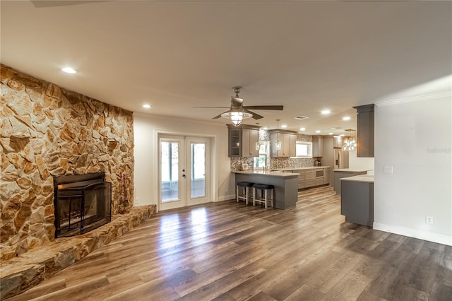 unfurnished living room with crown molding, a fireplace, dark hardwood / wood-style floors, and french doors