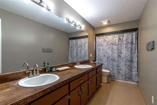 bathroom with a shower with curtain, vanity, tile patterned floors, and toilet