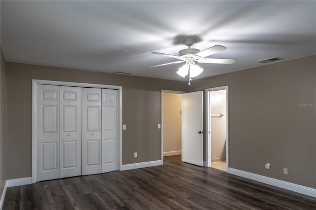 unfurnished bedroom with ceiling fan, dark hardwood / wood-style floors, and a closet