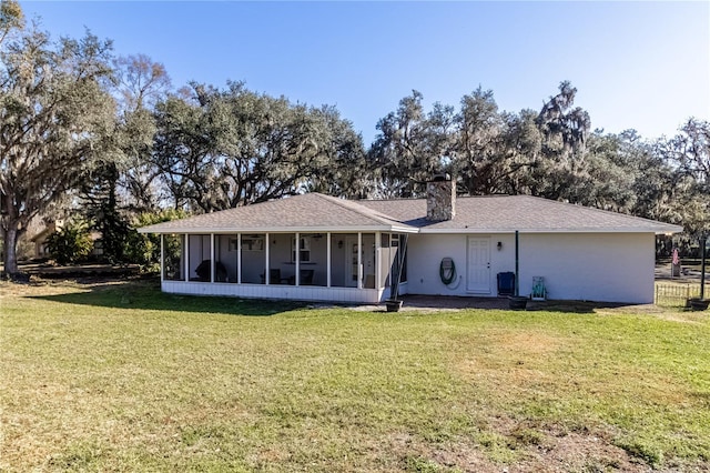 back of house featuring a lawn and a sunroom