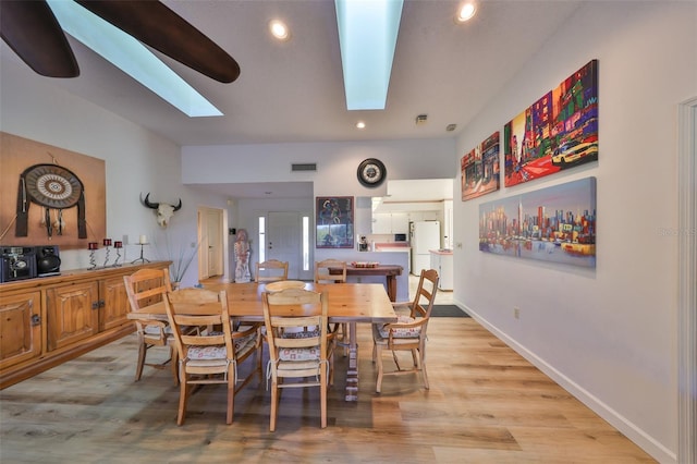 dining space featuring a skylight and light hardwood / wood-style flooring