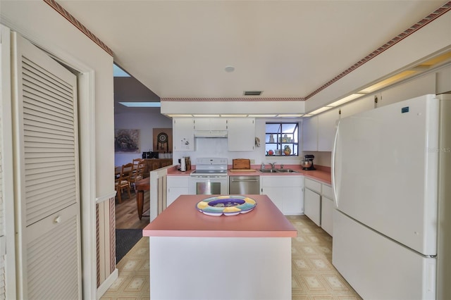 kitchen featuring sink, white appliances, a center island, and white cabinets