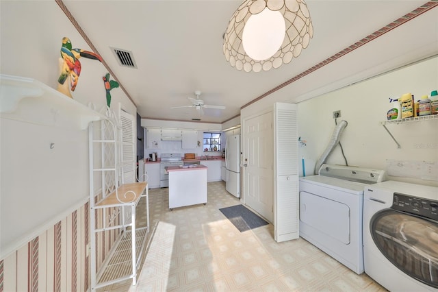 clothes washing area featuring crown molding, independent washer and dryer, and ceiling fan