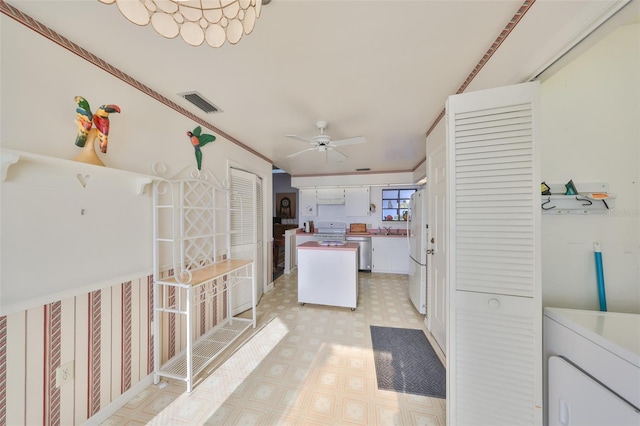 kitchen with range, dishwasher, white fridge, ceiling fan, and white cabinets