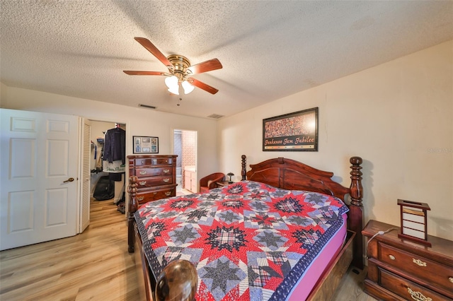 bedroom featuring hardwood / wood-style flooring, ceiling fan, and a textured ceiling