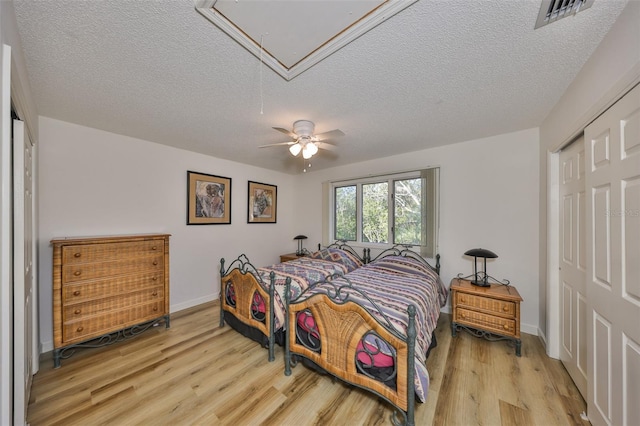 bedroom featuring ceiling fan, a closet, and light hardwood / wood-style flooring