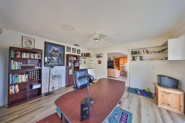 office space with ceiling fan, a textured ceiling, and light hardwood / wood-style flooring