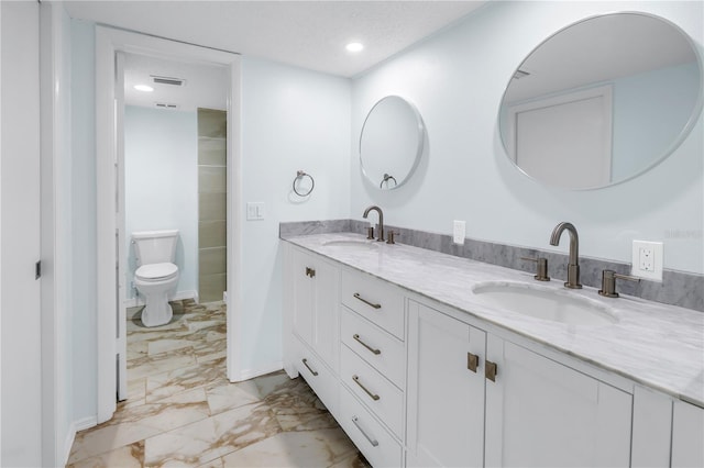 bathroom featuring vanity, a textured ceiling, and toilet