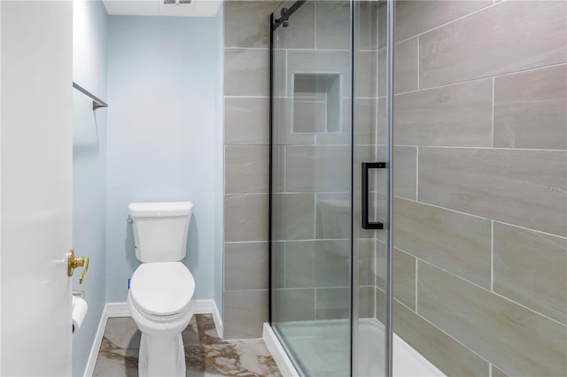 bathroom with a shower with door and toilet