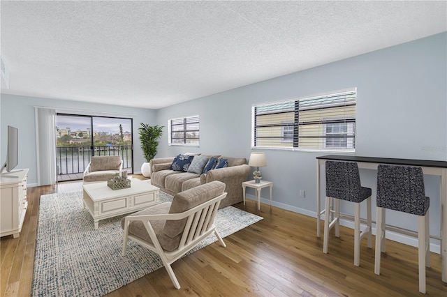 living room featuring light hardwood / wood-style flooring and a textured ceiling