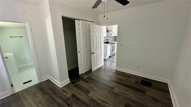 unfurnished bedroom with dark wood-type flooring, a closet, and ceiling fan