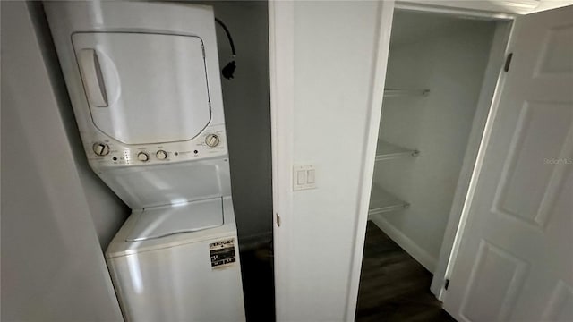 washroom with wood-type flooring and stacked washing maching and dryer