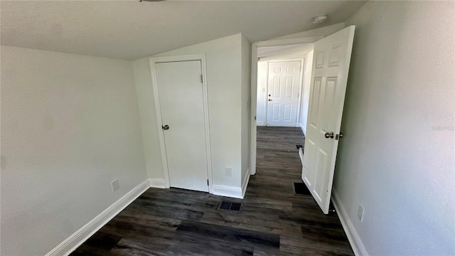 unfurnished bedroom with lofted ceiling and dark hardwood / wood-style floors