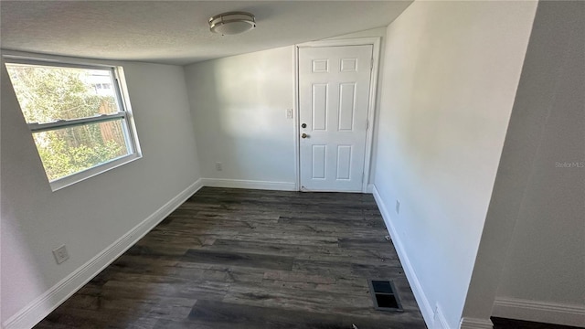 interior space featuring dark wood-type flooring and a textured ceiling